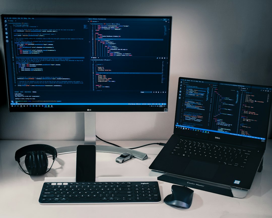 laptop computer beside monitor with keyboard and mouse